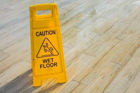 Wet floor caution sign warning of slip and fall hazard in a Florida store