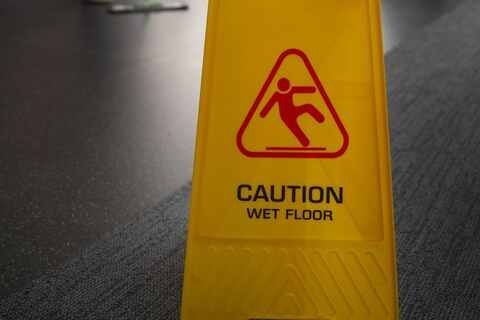 Caution wet floor sign on carpet after a slip and fall accident in Florida